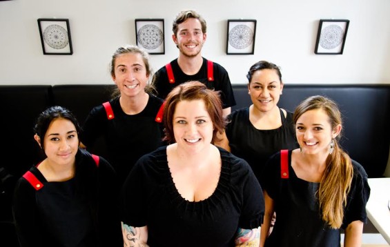  Back row:  Alex Robinson - deaf, NZSL (trainee chef) Middle row (l to r):  Bryn Carnelly - can hear, doesnt listen, learning sign (barista) Sophie Taua'i - hearing, learning sign (operations and training manager) Front row (l to r): Tagialofa Eneliko - deaf, NZSL (barista) Claire Matheson - hearing, learning NZSL (boss lady) Julz Russ - deaf, reads lips, learning NZSL (Cafe Manager)